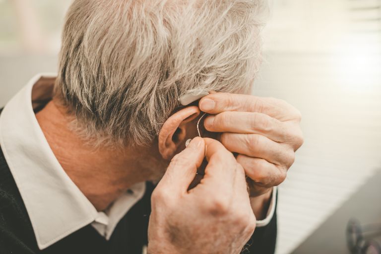 man putting in hearing aids