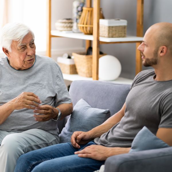 Man and older woman talking on the sofa