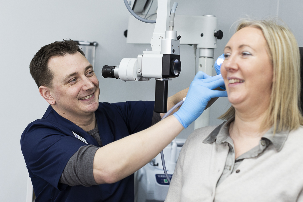 Audiologist looking in a womans ears